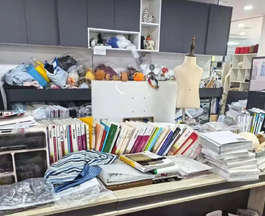Material samples, books and a dress form in the development studio